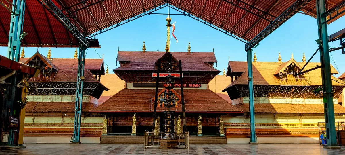 Kerala temple courtyard lit by rows of brass lamps at dawn